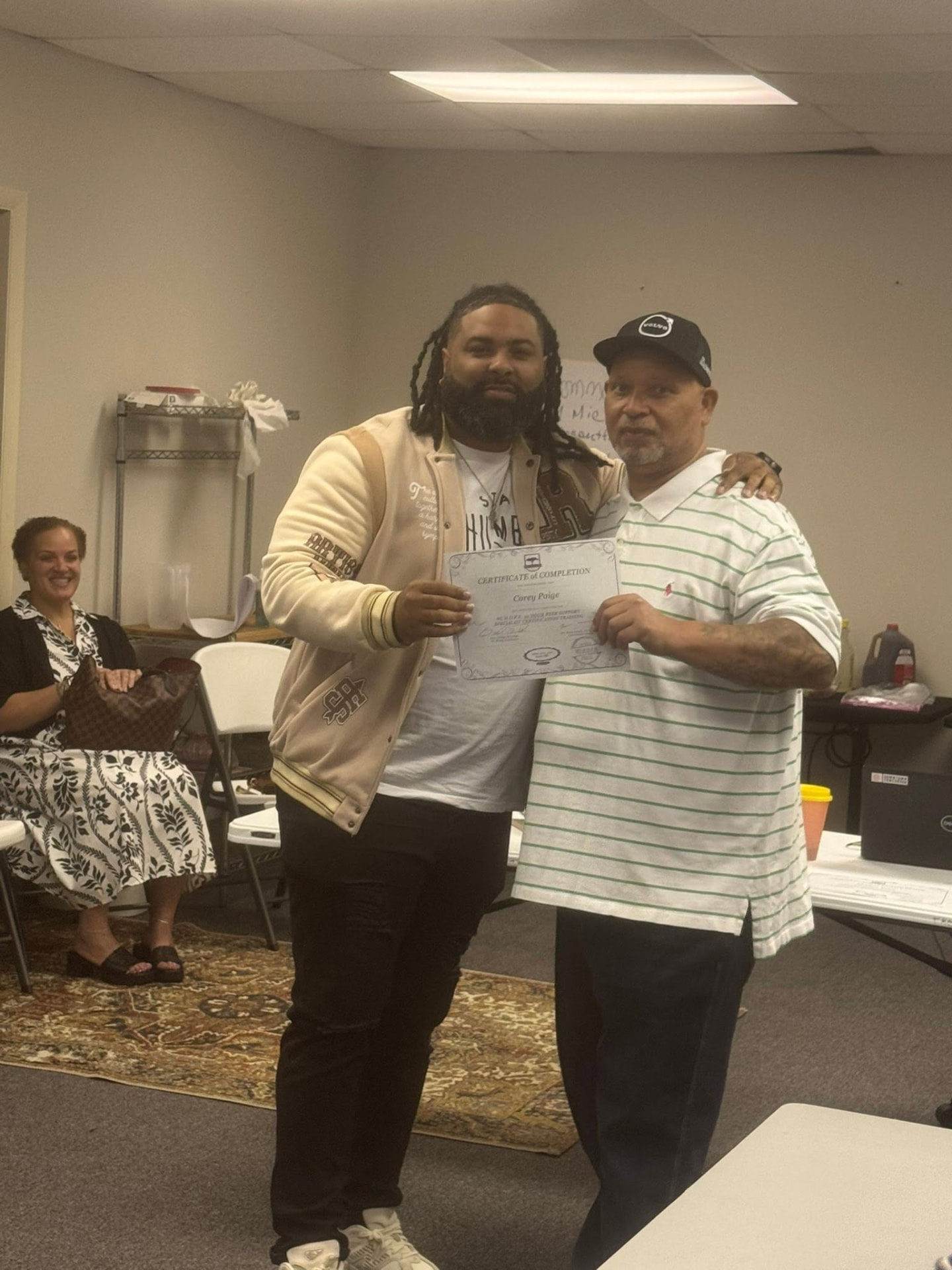 Earl Owens III presenting a certificate of completion to a graduate